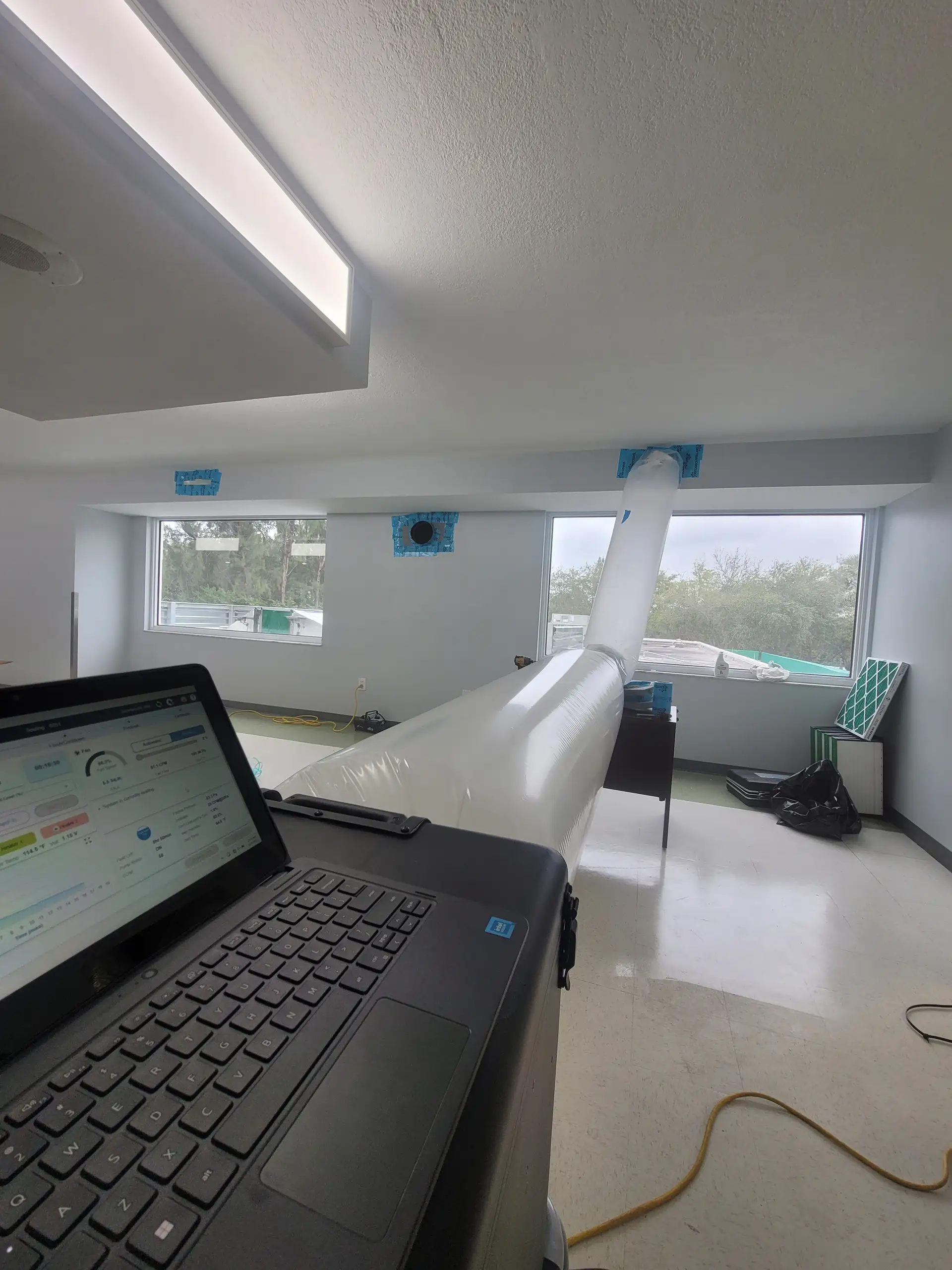 Clean Air Miami technician reviewing Aeroseal test results and duct leakage data